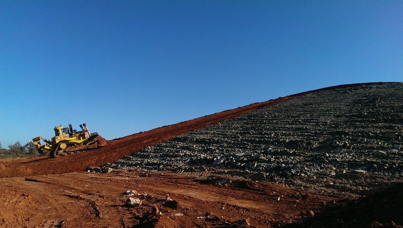 Dozer shaping a rehabilitated waste dump batter
